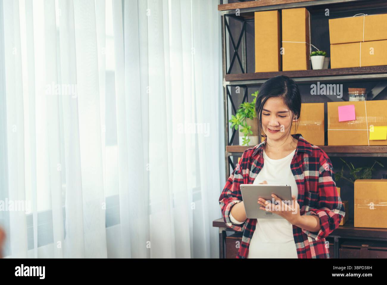 Asiatische Frau Startup Kleinunternehmen im Home Office. Online-Verkäufer Unternehmer junge asiatische Frau verwenden Tablet, um Online-Bestellung zu überprüfen. Frau mit Tablette c Stockfoto