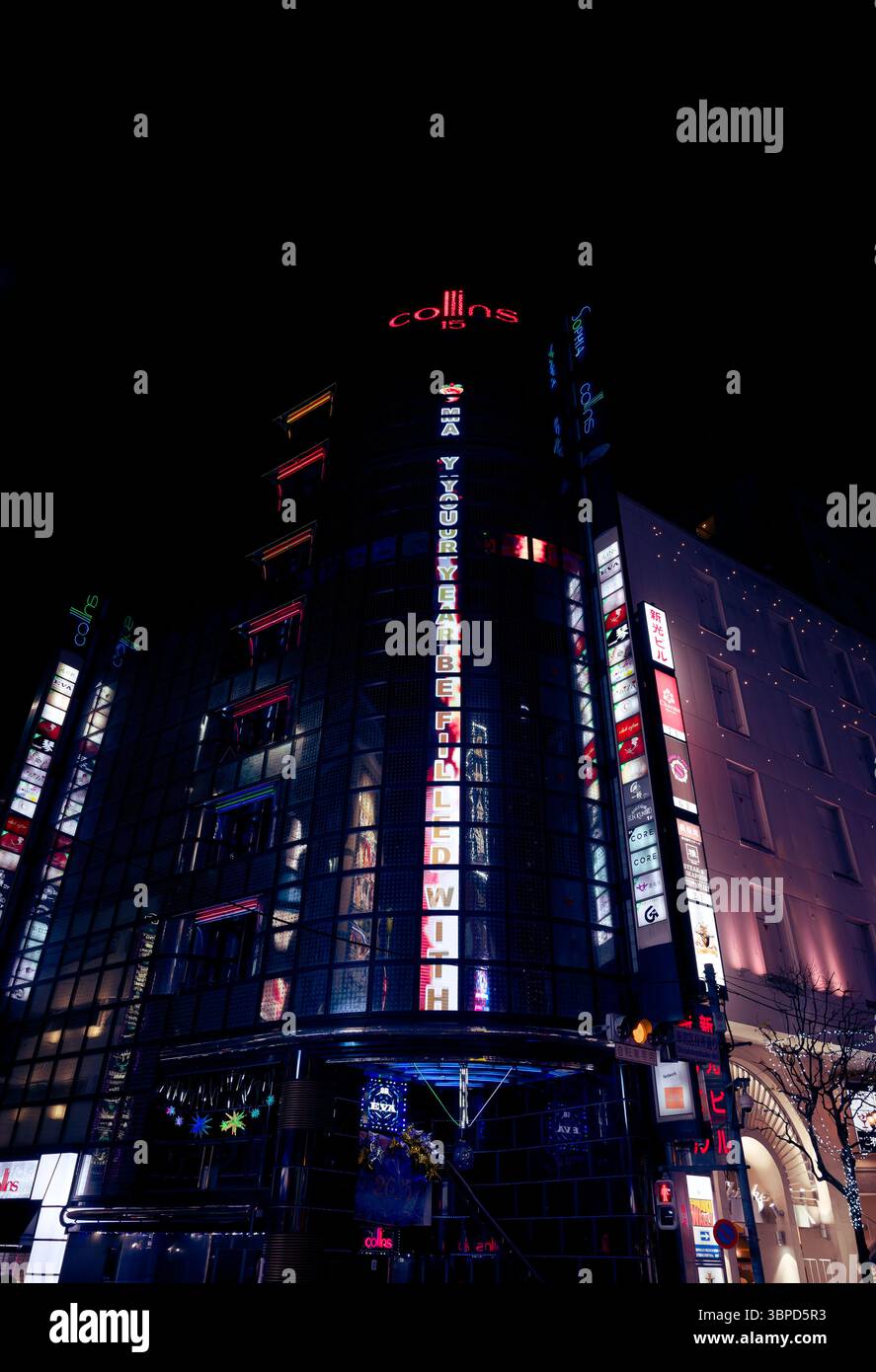 Das neonbeleuchtete Collins Building in Tokios Nachtleben leuchtet mit farbenfrohen Schildern am Nachthimmel Stockfoto