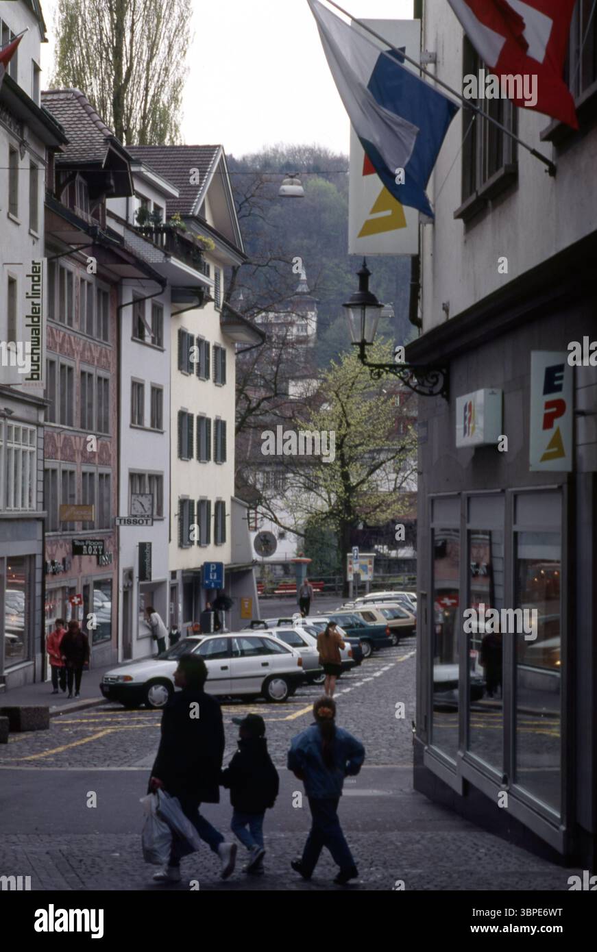 Luzern Schweiz Straßenszene mit Fußgängern, Fahnen und mittelalterlichem Turm Stockfoto