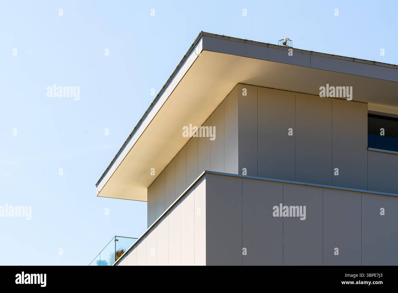 Modernes weißes Apartmentgebäude mit klaren Linien, Glasgeländern und minimalistischer Ästhetik Stockfoto