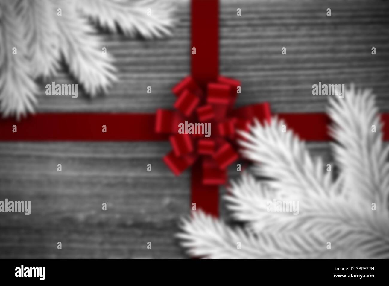 Das flache Design zeigt ein rotes Satinband, das graue Holzdielen mit weißen Nadelzweigen kreuzt Stockfoto