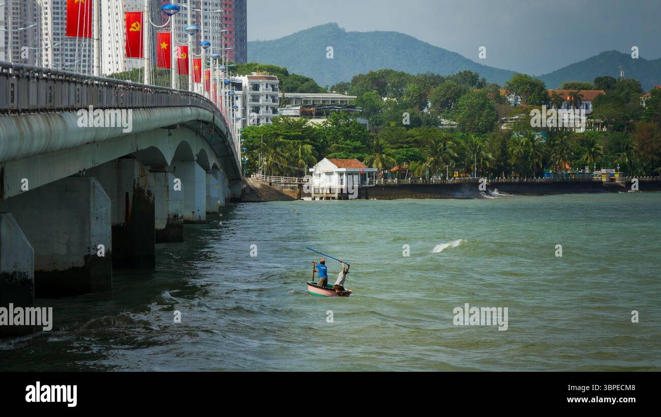 Traditionelle vietnamesische Fischer in einem runden Korbboot unter der Tran Phu Brücke, Nha Trang, Vietnam Stockfoto
