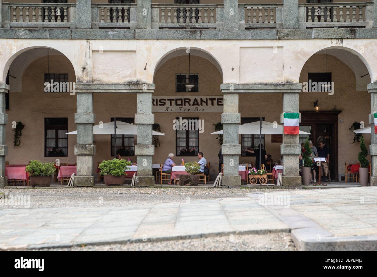 Alcuni turisti seduti in uno dei ristoranti del luogo si godono il pranzo. Oropa, Biella, Italien Stockfoto