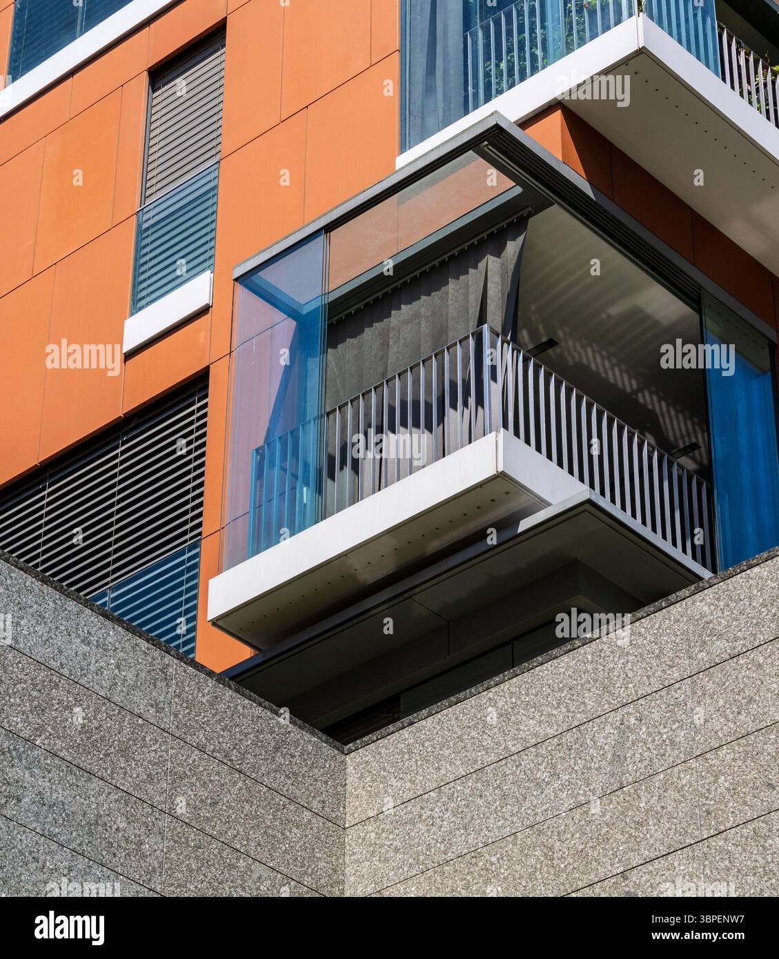 Architektonische Details einer Glasterrasse an der Ecke eines modernen Wohngebäudes. Die Struktur unterstreicht zeitgenössisches urbanes Design Stockfoto