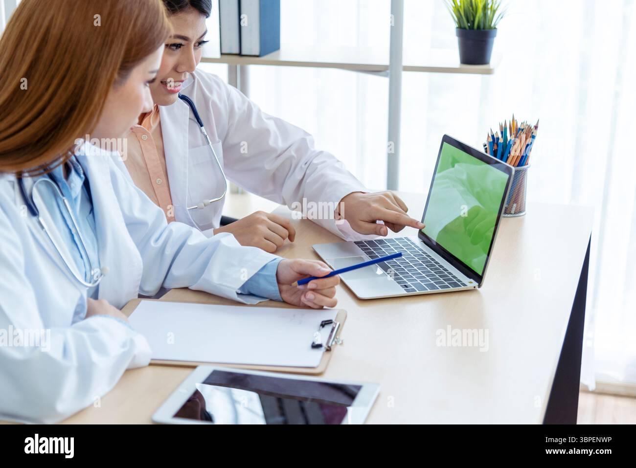 Zwei asiatische Ärztinnen diskutieren Besprechung Arztpraxis medizinische Klinik mit Laptop Beratung Patientenkrankheit. Asiatisches medizinisches Labor, junge Frauen im Gespräch Stockfoto