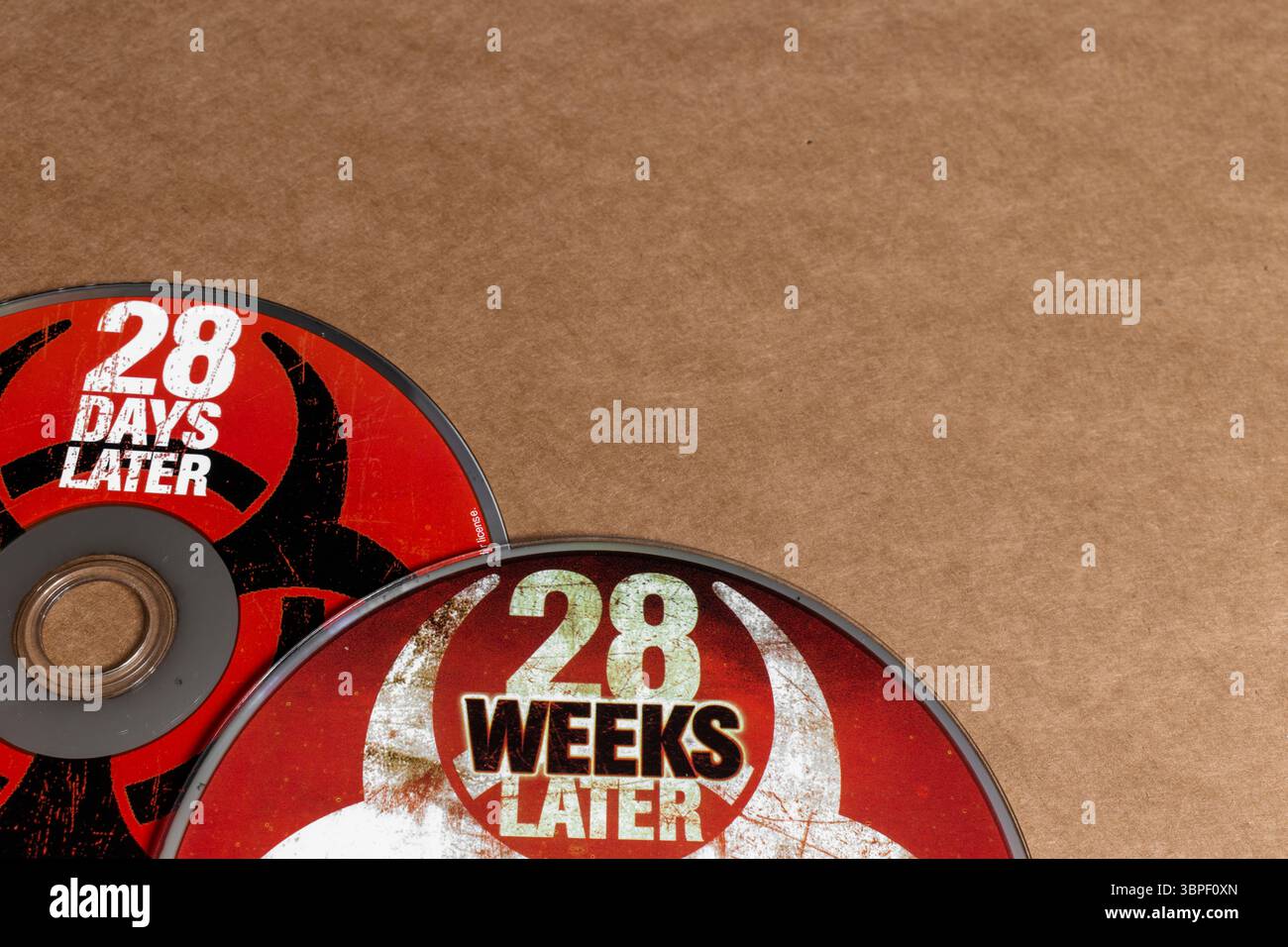 28 Tage später und 28 Wochen später Horrorfilm-DVDs mit Biohazard-Symbolen auf Papphintergrund Stockfoto