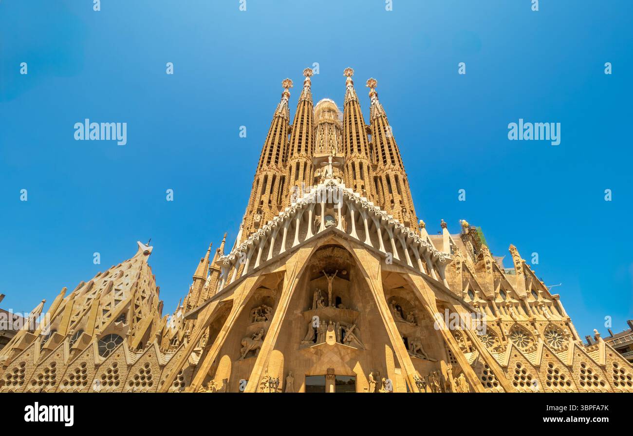 Flacher Blick auf die hoch aufragenden Türme der Passionsfassade bei Antoni Gaudí unvollendetem Meisterwerk, La Sagrada Familia, Barcelona, Spanien. Stockfoto