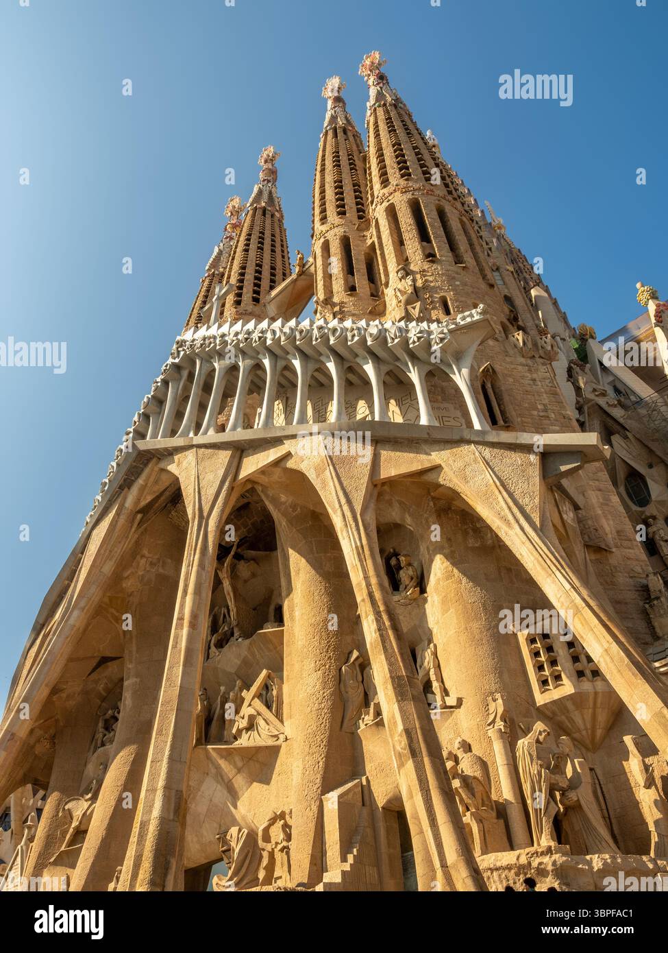 Flacher Blick auf die hoch aufragenden Glockentürme der Passionsfassade in La Sagrada Familia in Barcelona, Spanien. Stockfoto