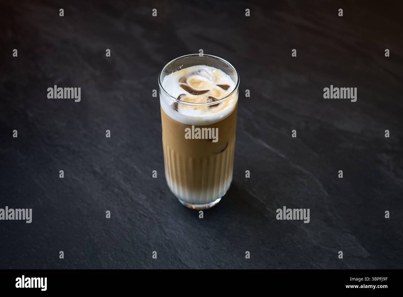 Eiskaffee in hohem Glas auf dunklem Hintergrund Stockfoto