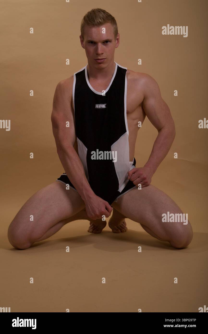 Ein muskulöses männliches Model, das ein schwarz-weißes KIK-Tanktop mit Shorts trägt Stockfoto