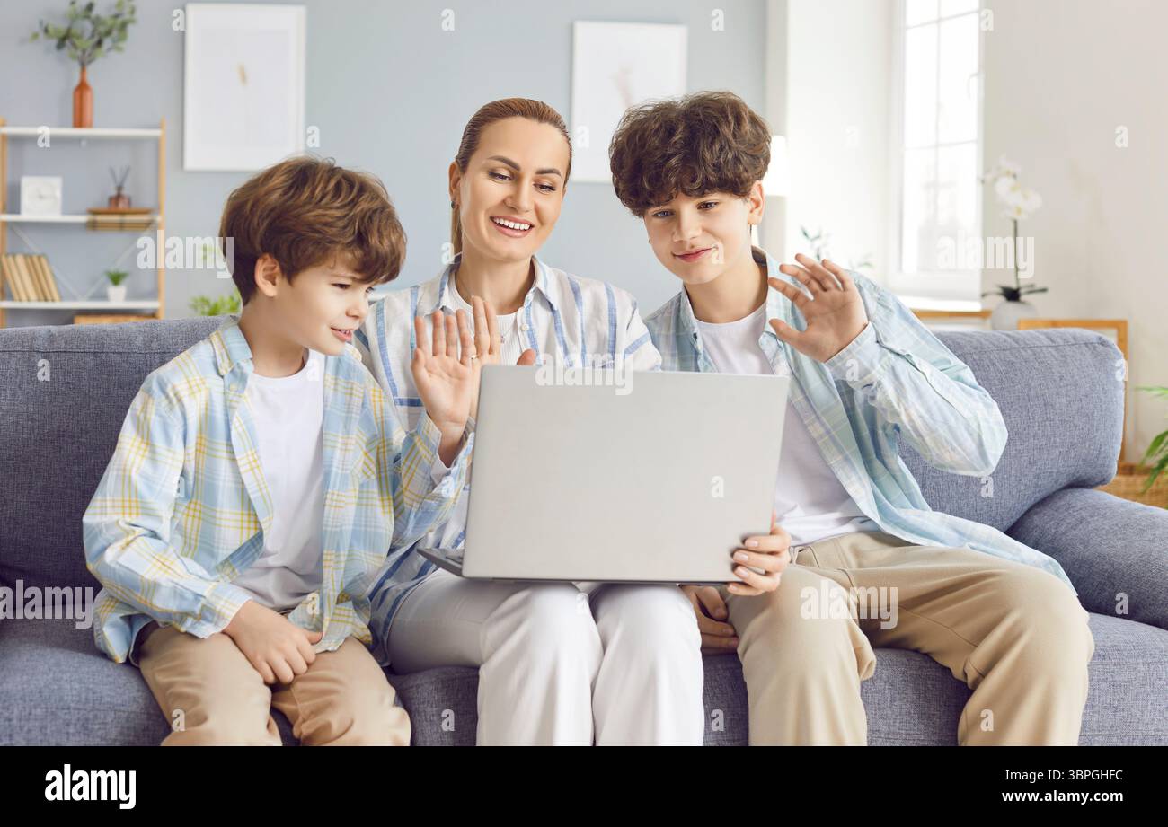 Glückliche Mutter Mit Zwei Söhnen Bei Online-Videoanruf Auf Laptop Zu Hause Stockfoto