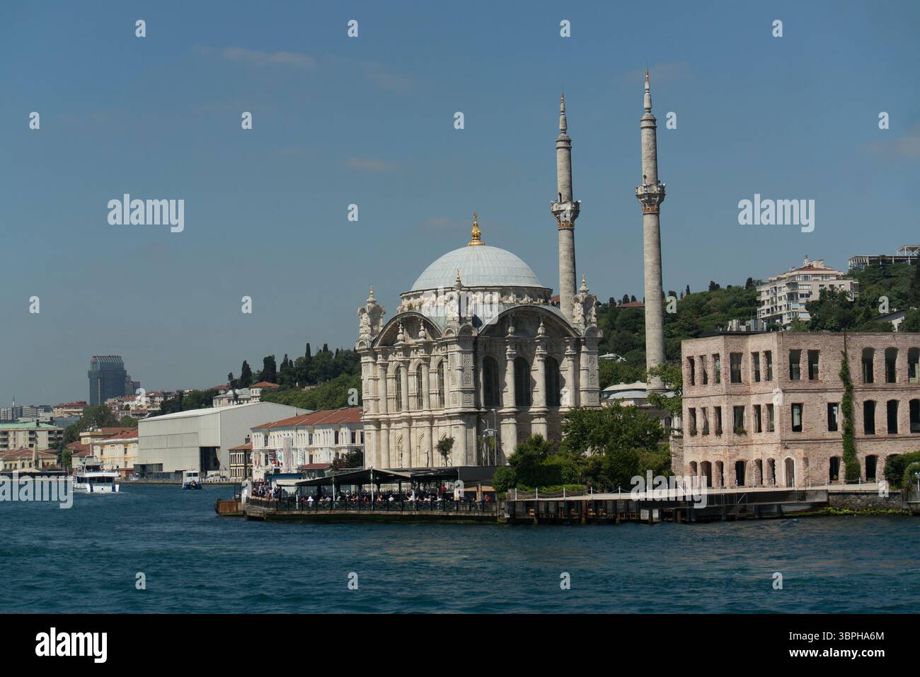 Die Ortakoy Moschee steht majestätisch am Bosporus und zeigt ihre atemberaubende Architektur unter der hellen Mittagssonne in Istanbul. Stockfoto