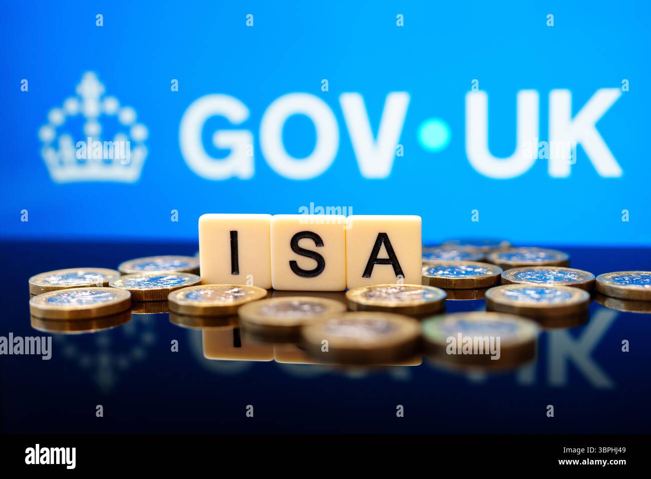 ISA-Buchstabenkacheln mit britischen Pfund-Münzen vor dem Hintergrund DES britischen REGIERUNGSBEZIRKS, die die von der britischen Regierung unterstützte steuerfreie Sparregelung veranschaulichen. Stafford, Vereinigtes Königreich Stockfoto