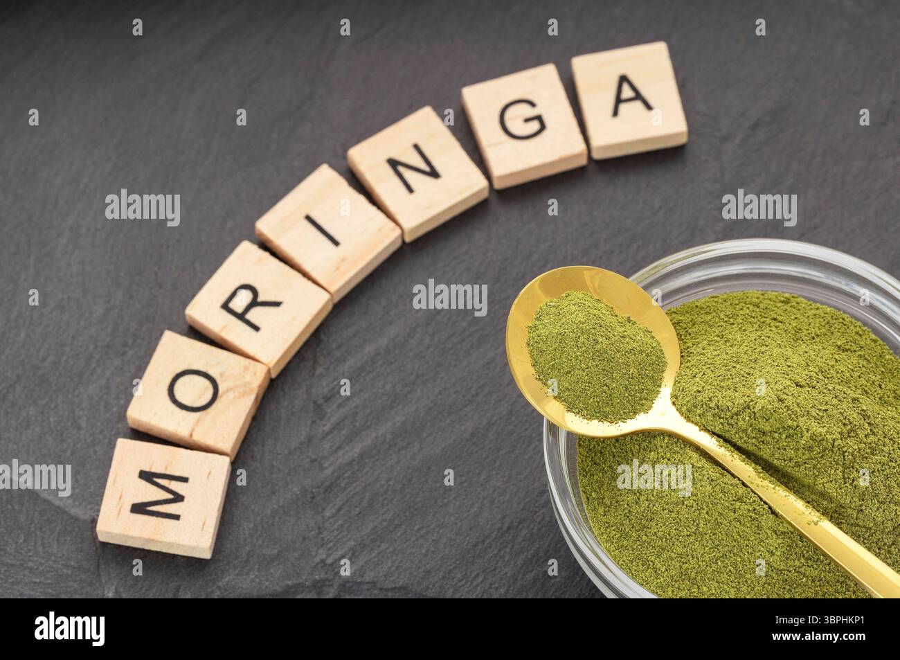 Organisches grünes Moringa-Pulver in einer Schüssel und einem Löffel - Moringa oleifera Stockfoto
