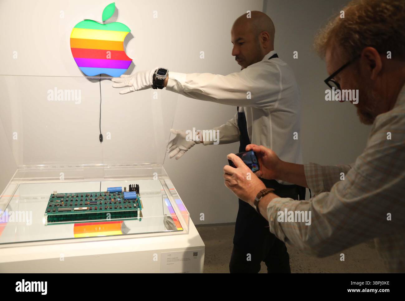 New York, New York, USA. Juli 2025. Ein Handler, der mit dem Apple-1 Computer Motherboard „˜Romkey“ gesehen wurde, dem besten funktionsfähigen Apple-1, das es gab, aus der ersten Serie von 50 handgefertigten Exemplaren von Wozniak und Jobs im Jahr 1976, schätzte 400.000 bis 600.000 US-Dollar und Apple Computer, Inc Original Apple Logo Light, ca. 1990er Jahre Schätzungsweise 10.000 - 000 Dollar, bei der Pressevorschau für die Geek Week 2025 im Sotheby's New York. (Kreditbild: © Nancy Kaszerman/ZUMA Press Wire) NUR REDAKTIONELLE VERWENDUNG! Nicht für kommerzielle ZWECKE! Stockfoto