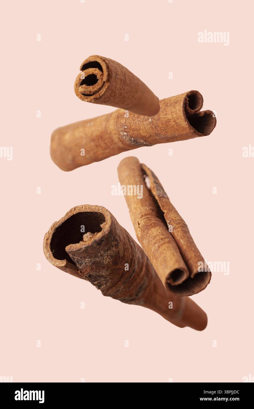 Zimtstäbchen fliegen auf beigefarbenem Hintergrund, Nahaufnahme Stockfoto