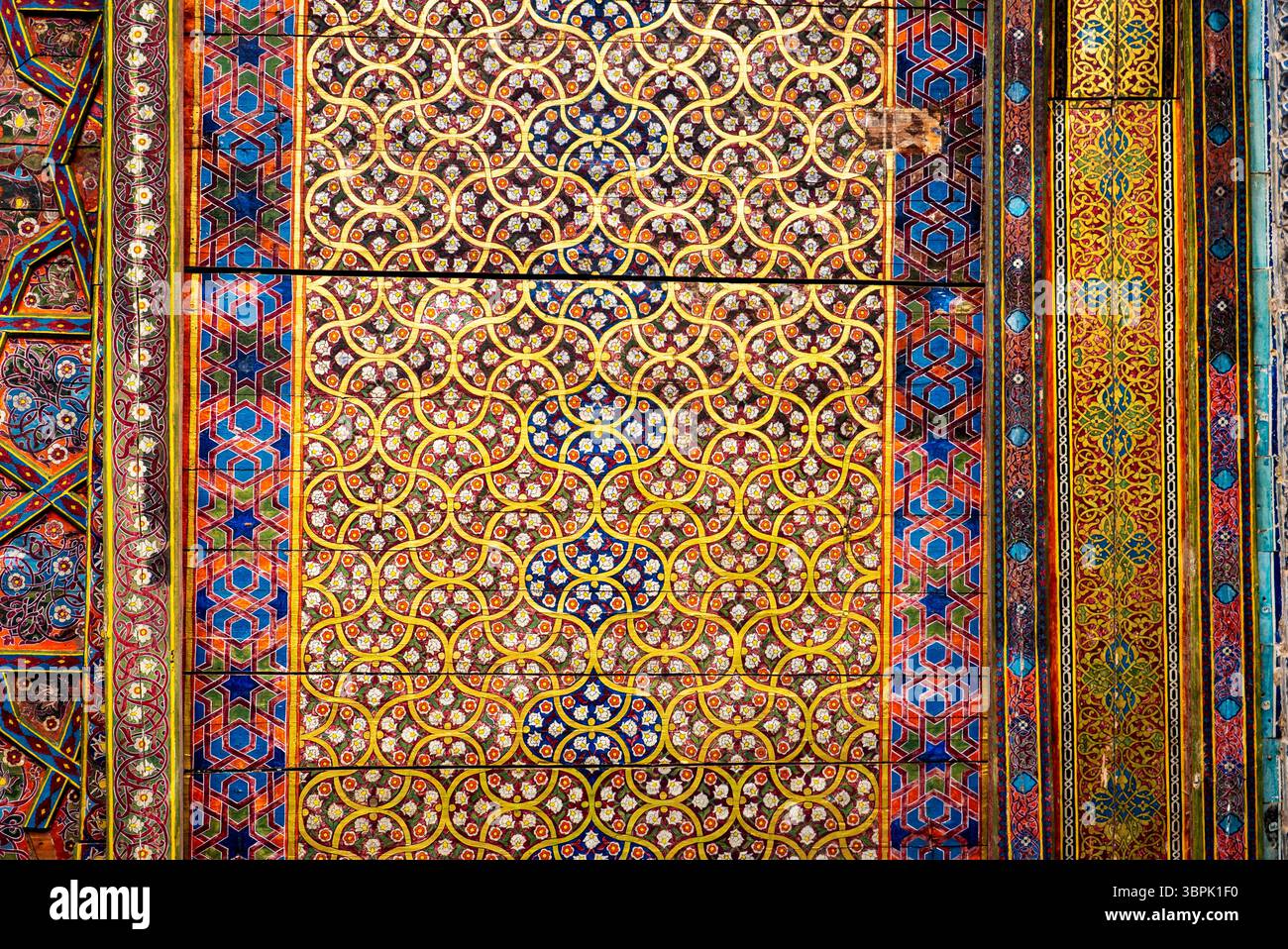 Ein lebendiges und kompliziertes Muster mit geometrischen Formen und Blumenmustern in kräftigen Farben wie Rot, Blau, Gelb und Grün. Das Kunstwerk zeigt Stockfoto