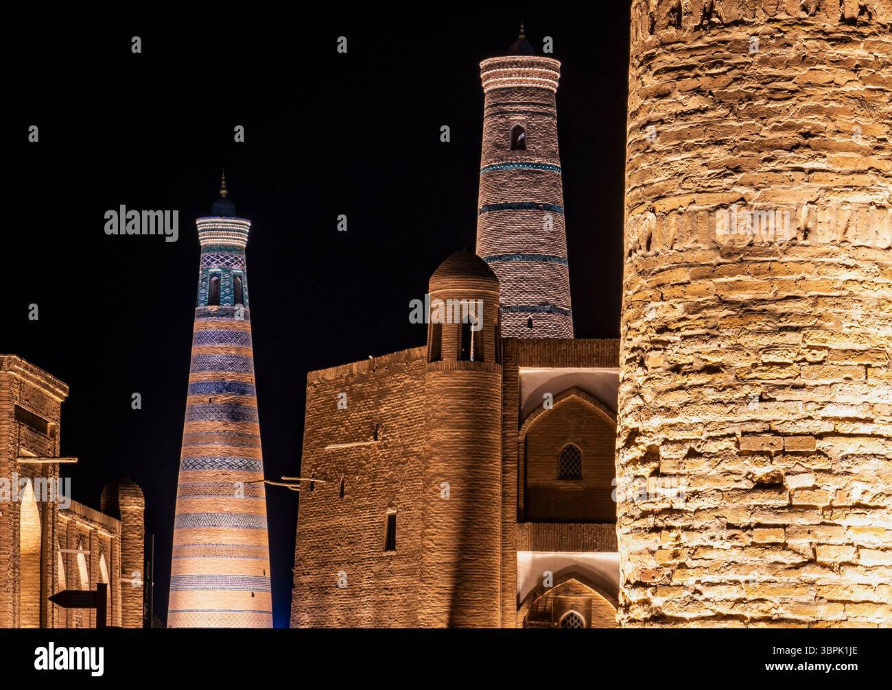 Beleuchtete historische Türme und antike Architektur bei Nacht mit komplexen Designs und Texturen. Stockfoto