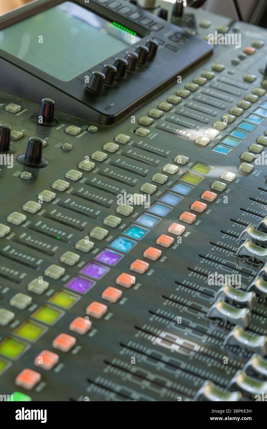 Nahaufnahme einer professionellen Audio-Mischkonsole, die die verschiedenen Fader, Regler und Tasten für die Tontechnik und Musikproduktion hervorhebt Stockfoto