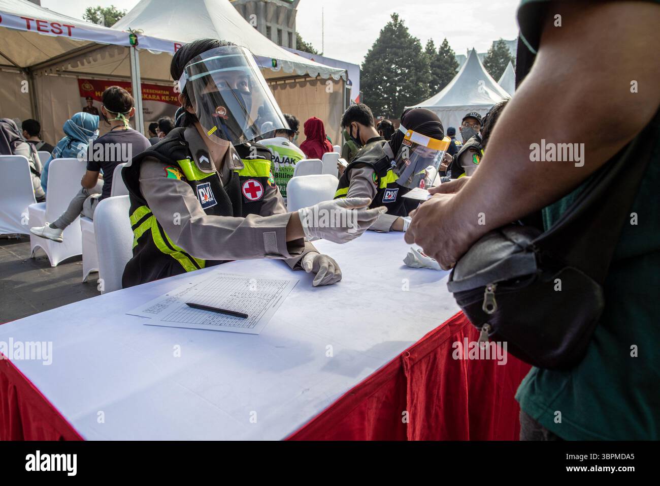 Juni 2020, Jakarta, Jakarta, Indonesien: Jakarta, Indonesien, 21. Juni 2020: Einreiseverfahren für Polizisten für Personen, die den Schnelltest haben wollen. Polizei Jakarta Gesundheit Abteilung hielt Massenschnelltest für Besucher an autofreien Tag in Jakarta. Bei insgesamt 1000 Zielpersonen reagieren 850 mit 4 Testpersonen auf den Test und setzen den Abstrichtest fort. Der Schnelltest in Indonesien wurde kontinuierlich durchgeführt, um genau die Personen zu erhalten, die sich mit dem Virus infiziert haben. (Bild: © Donal Husni/ZUMA Wire) Stockfoto