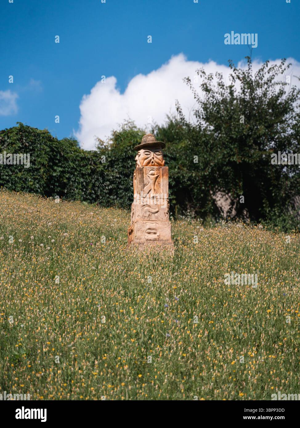 Steinskulptur, die heidnische Traditionen in Opishnia, Poltawa, Ukraine, inmitten von üppigem Grün und klarem Himmel darstellt Stockfoto