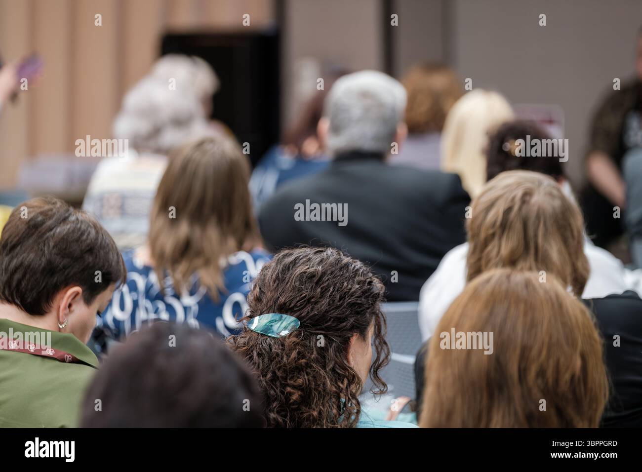 Publikum hört aufmerksam zu bei einem Bildungsseminar oder einer Konferenz in einem Innenbereich Stockfoto