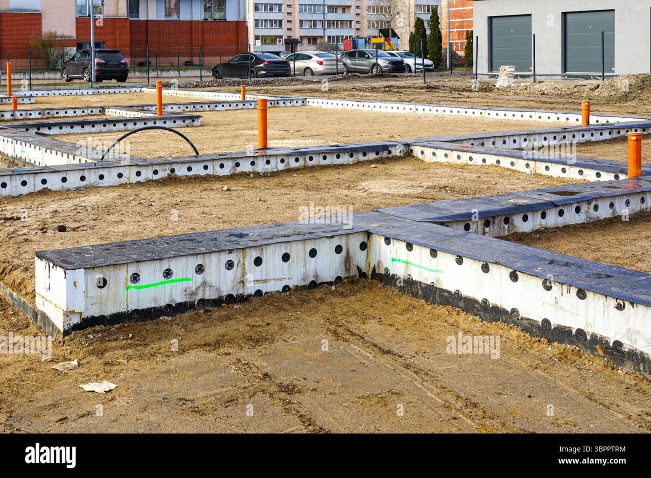 Modernes Gebäudefundament im Bau mit isolierten Formen, Versorgungsleitungen, struktureller Grundriss Stockfoto