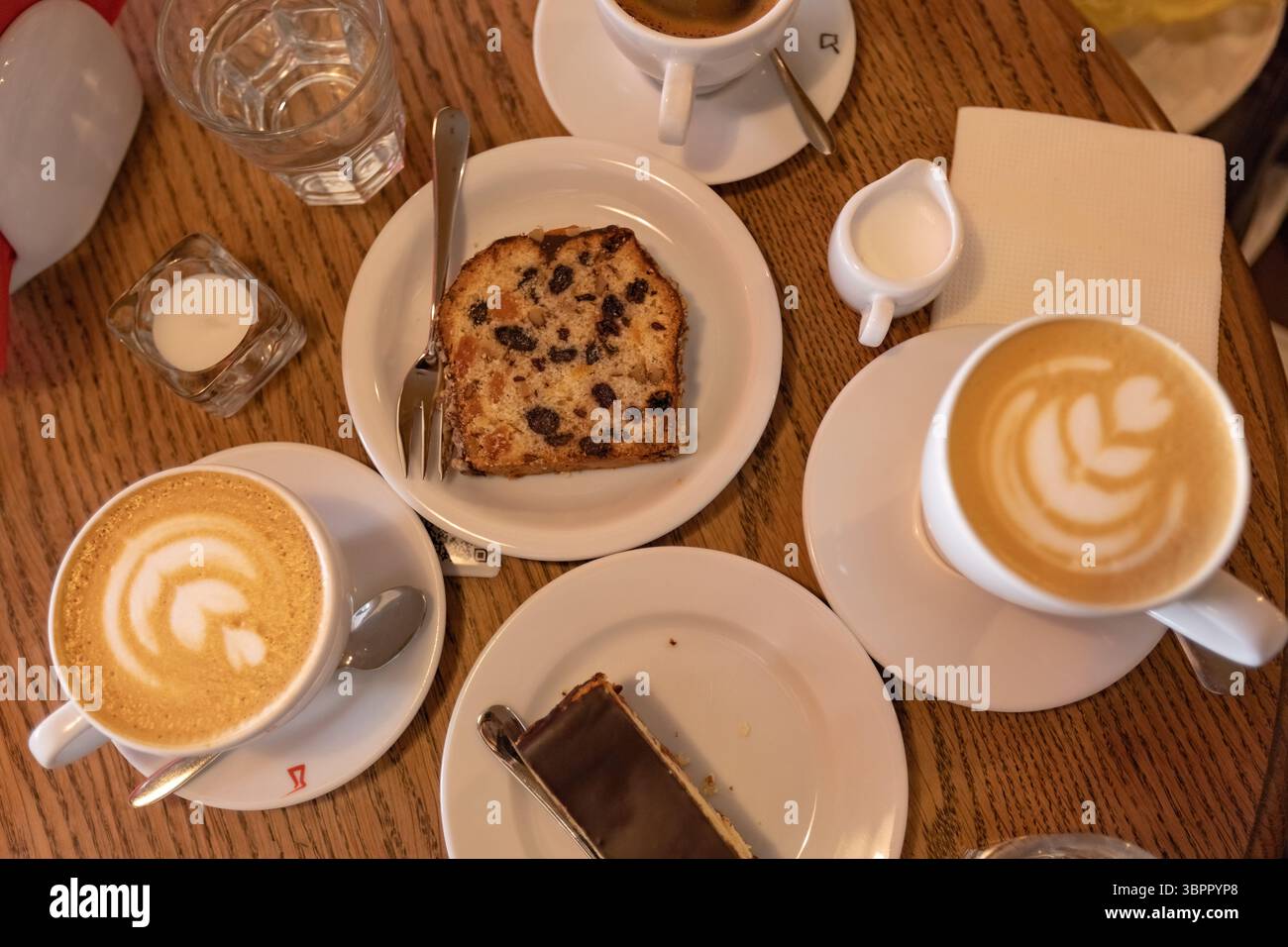 Blick von oben auf den Couchtisch mit Kaffeetassen und Desserts Stockfoto