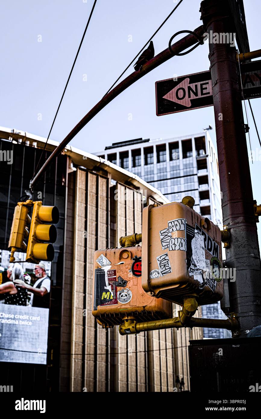 Ampel- und Straßenschilder mit Aufklebern auf Kontrollkästen vor dem Madison Square Garden, New York City, USA Stockfoto