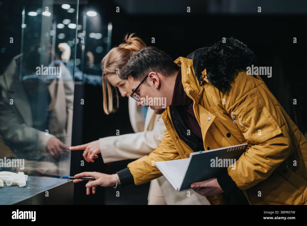Zwei Personen, die eine Museumsausstellung genau untersuchen Stockfoto
