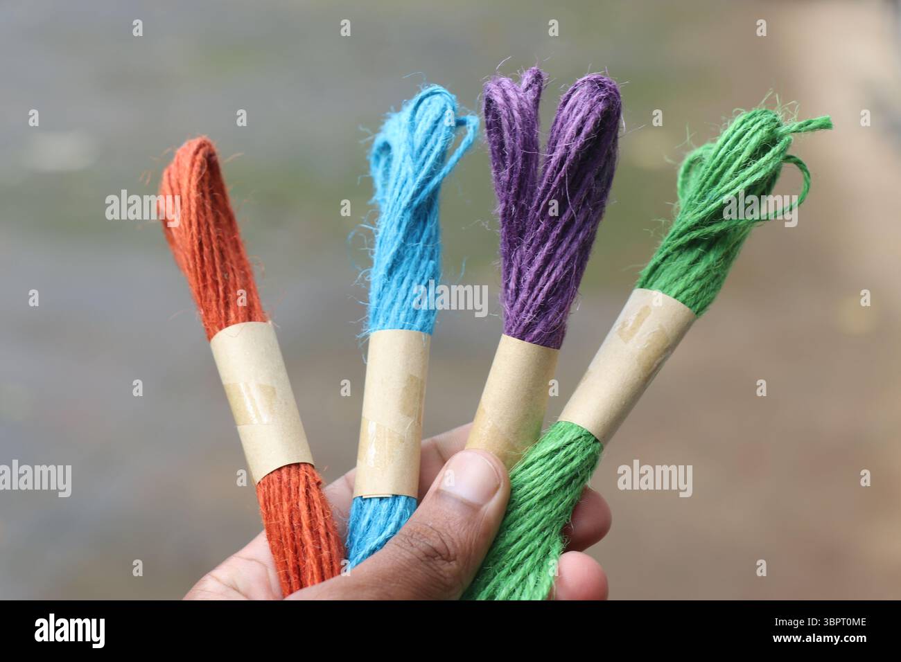Bunte Jute-Seile für Kunsthandwerk in der Hand bei Tageslicht Stockfoto