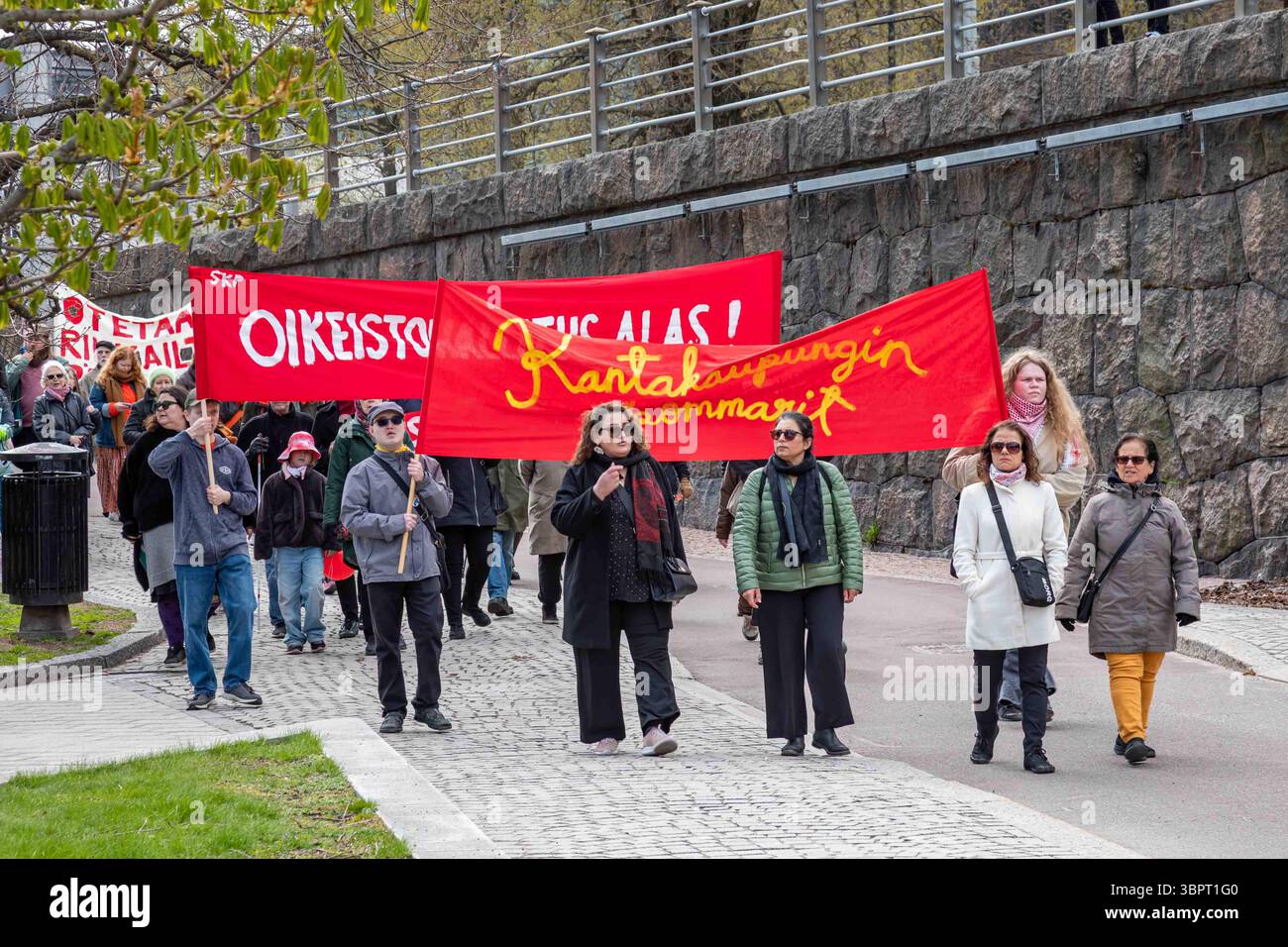 Kantakaupungin kommarit. Kommunisten mit roten Fahnen bei der Maikundgebung in Helsinki, Finnland. Stockfoto
