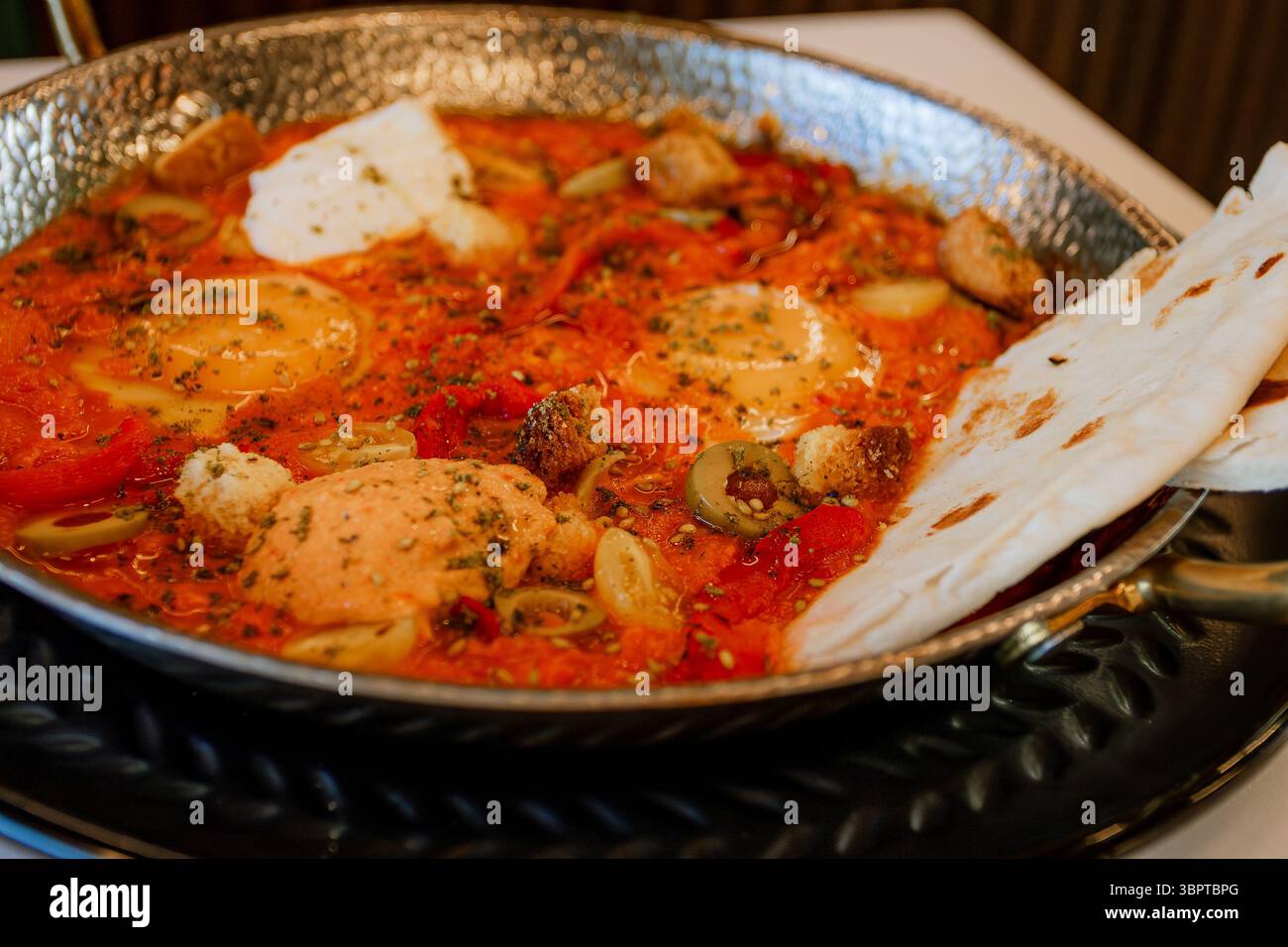 Shakshuka-Gericht mit Eiern, Tomatensauce und Pitabrot Stockfoto