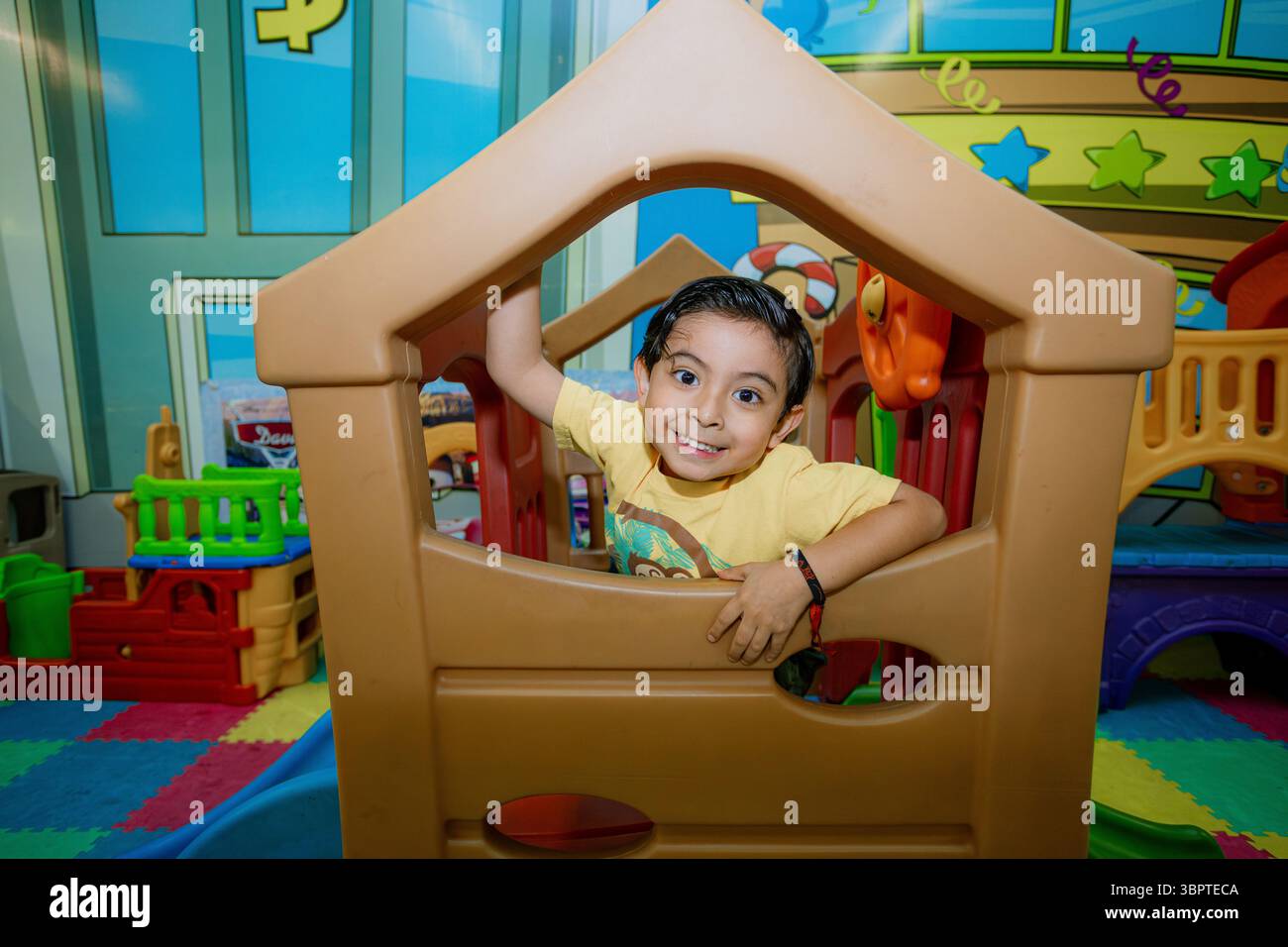 Der lächelnde Junge spielt auf dem Spielplatz für Kinder Stockfoto