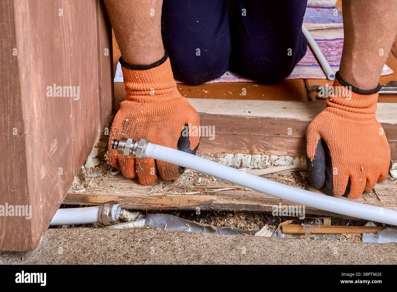 Der Sanitär-Spezialist verbindet geteilte mehrschichtige Schläuche mithilfe von Kompressionsanschlüssen wieder, um defekte Rohrleitungen wiederherzustellen, die durch den Bruch bei kaltem Wetter verursacht wurden. Stockfoto