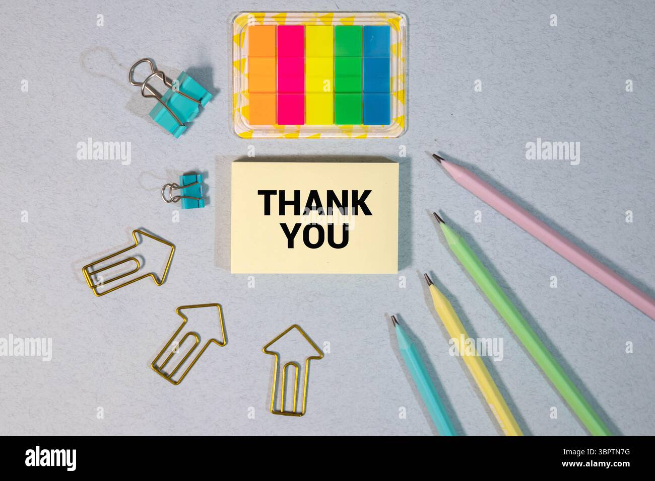 Junger gutaussehender kaukasier isoliert auf gelbem Hintergrund, der ein Plakat mit Text hält, DANKE mit Daumen nach oben Stockfoto