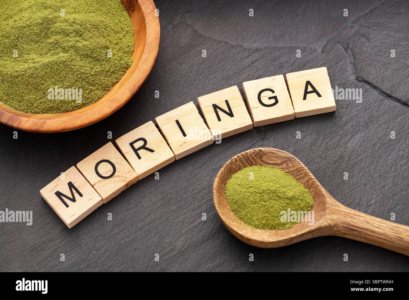 Moringa oleifera – natürliches und biologisches grünes Moringa-Pulver in einem Löffel und einer Schüssel Stockfoto