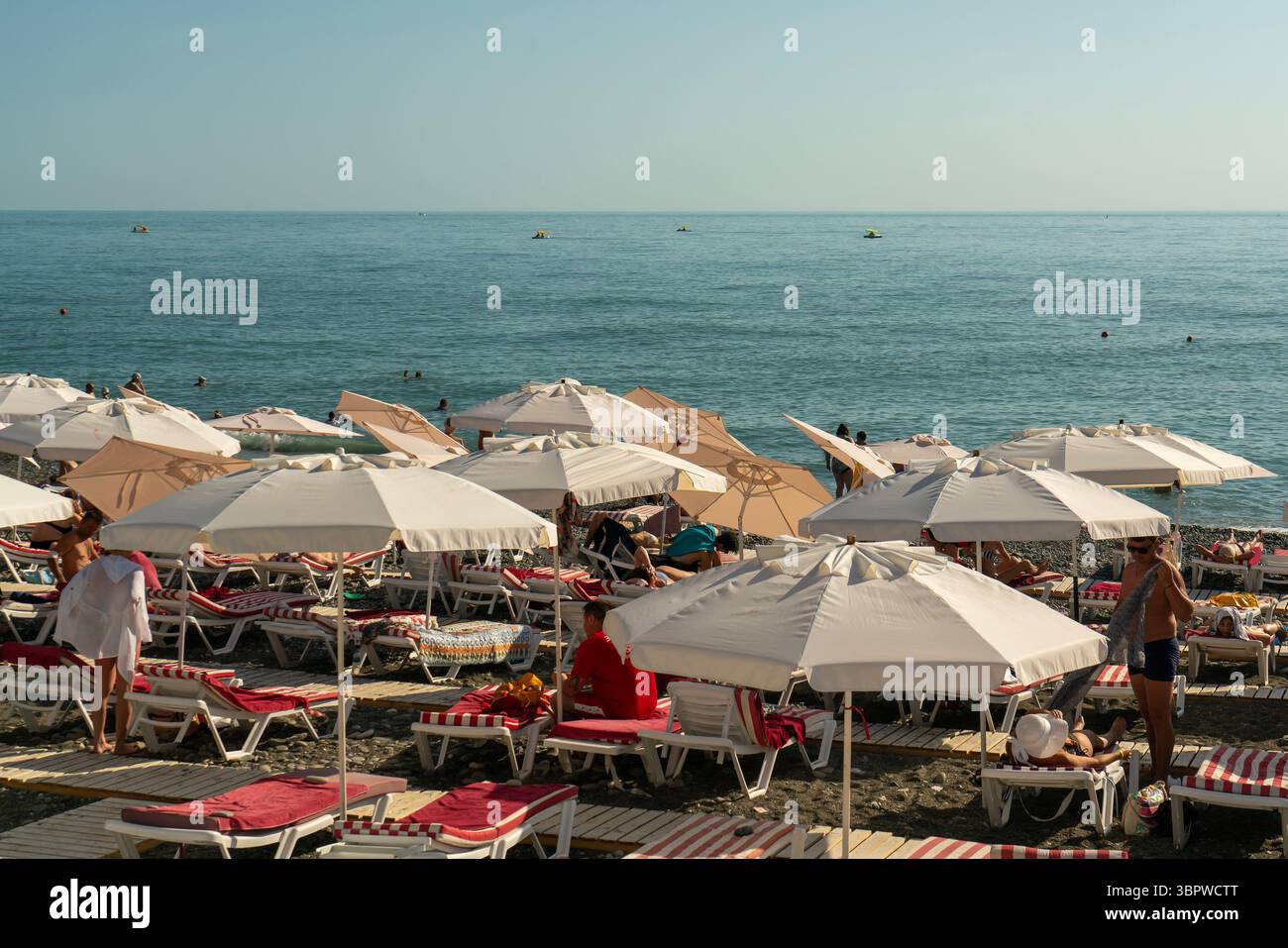 Sotschi, Russland - 05. Juli 2022: Stadtstrand am Meer mit Liegestühlen und Sonnenschirmen. Stockfoto