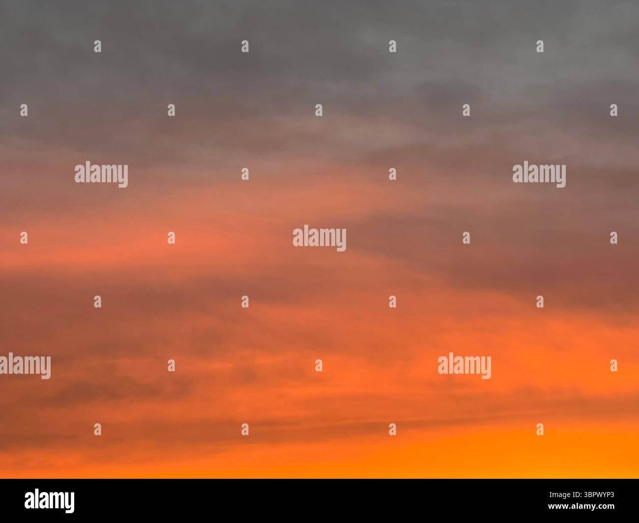 Ein atemberaubender Sonnenuntergang färbt den Himmel mit wunderschönen Orange- und Grautönen. Stockfoto