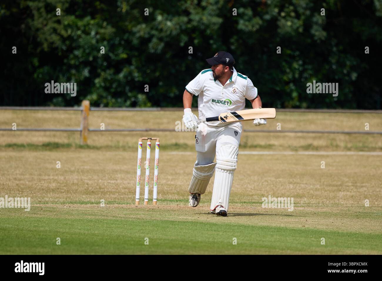 Ein Amateur-Schlagmann, der einen Lauf in einem Dorfleucketspiel startet, Stockfoto