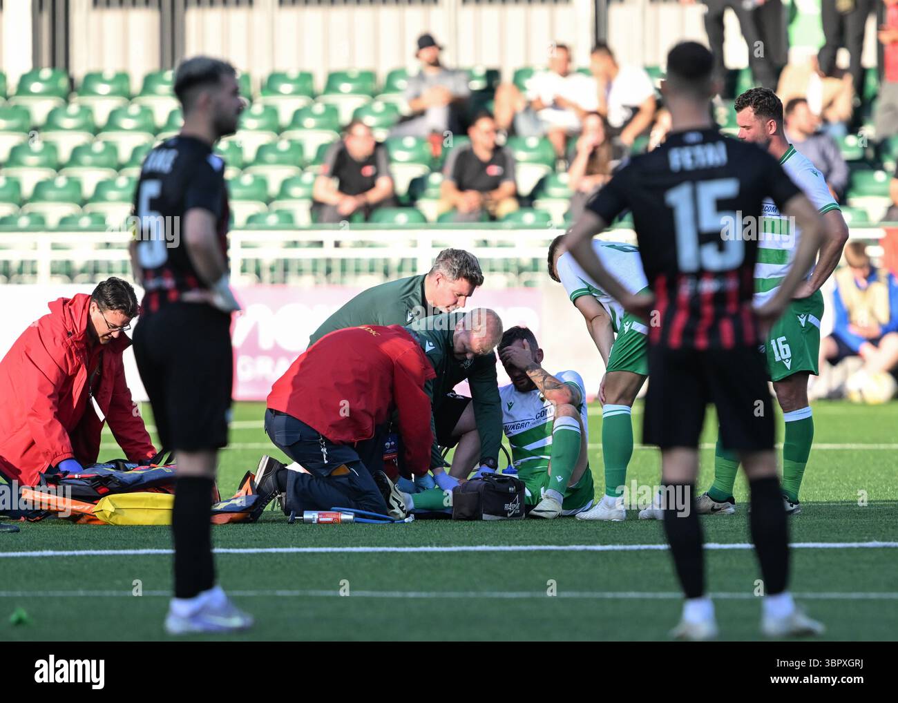 Park Hall Stadium, Oswestry, Shropshire, England, 8. Juli 2025.Leo Smith von den New Saints wird von medizinischem Personal wegen einer Verletzung behandelt, bevor er während des New Saints of Oswestry Town & LlansantffRAID Football Club/The New Saints (TNS) gegen KF Shkëndija/Klubi i Futbollit Shkëndija (Shkëndija) in der ersten Qualifikationsrunde der Champions League 2025/2026 in Park Hall ausgestreckt wird. (Kreditbild: ©Cody Froggatt/Alamy Live News) Stockfoto