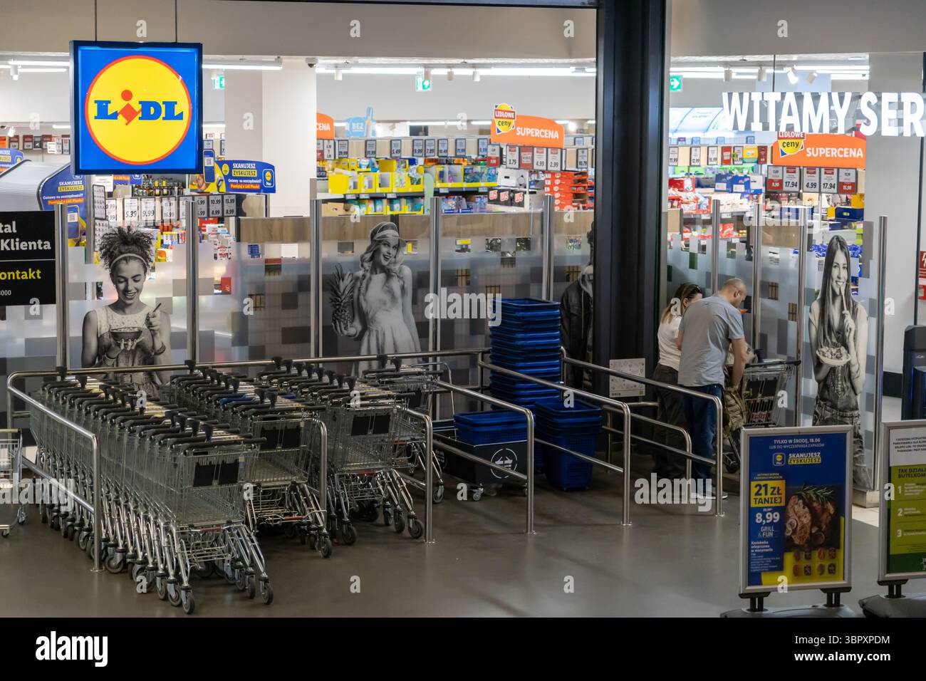 Posen, Polen - 18. Juni 2025: Innenansicht eines LIDL-Supermarktes mit Käufern und ordentlich angeordneten Einkaufswagen, die den modernen Supermarkt repräsentieren Stockfoto