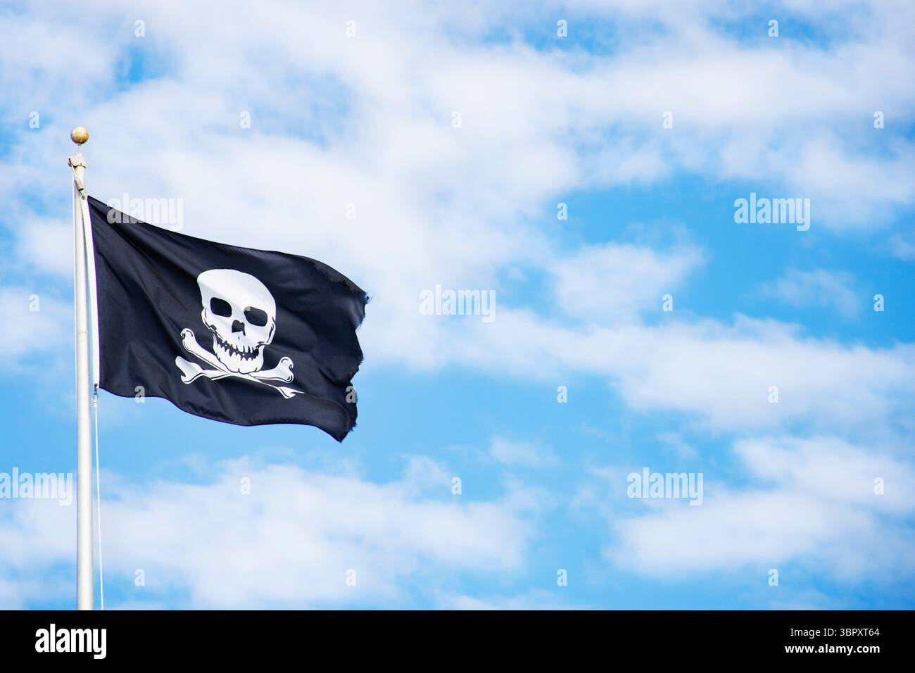 Piratenfahne am Himmel mit weißen Wolken Stockfoto