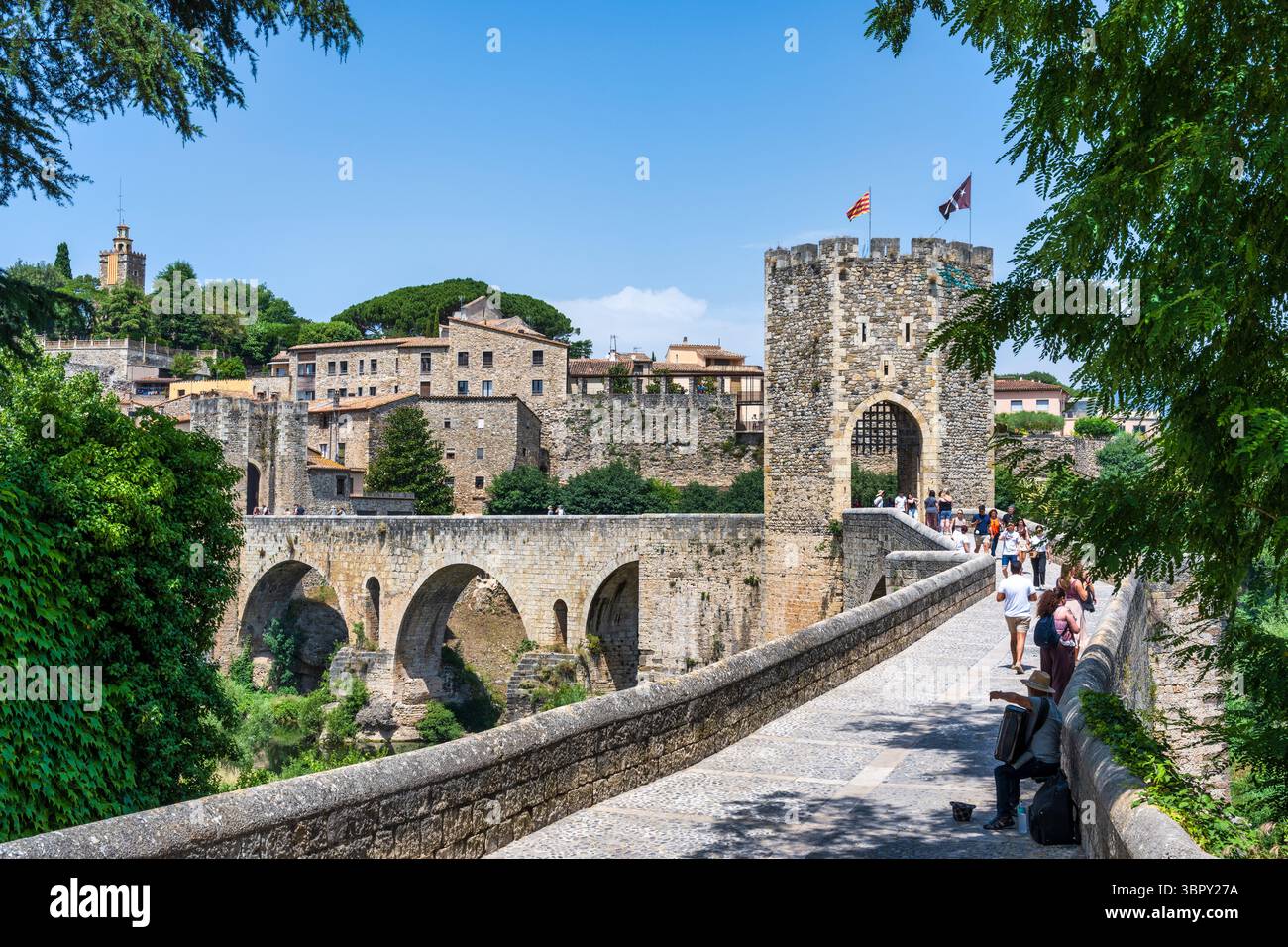 Besucher auf der romanischen Brücke aus dem 12. Jahrhundert über den Fluvia in der mittelalterlichen Stadt Besalú in der spanischen Region Katalonien Stockfoto
