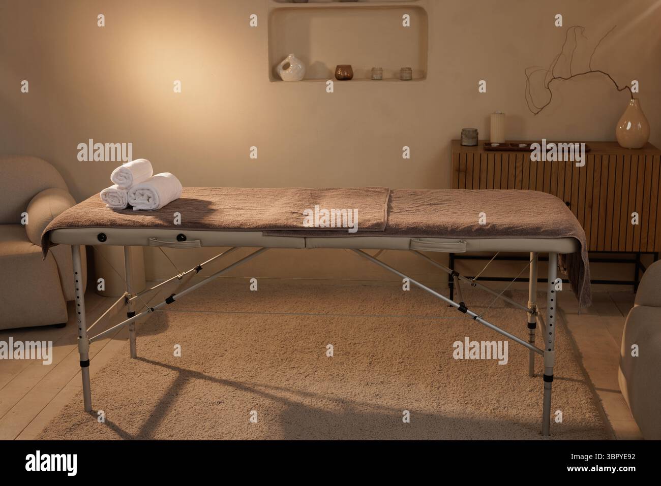 Professioneller Massagetisch mit Handtüchern in ruhiger Spa-Einrichtung, perfekt für Wellness- und Entspannungstherapie. Stockfoto