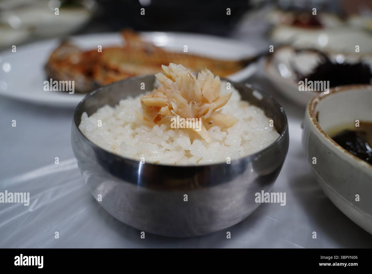Gegrillter Fisch auf gedämpftem weißem Reis. Traditionelle Koreanische Mahlzeit Präsentation Stockfoto