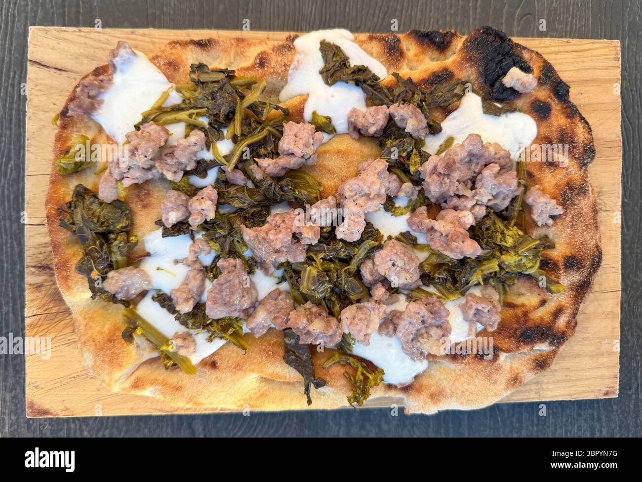 Fladenbrot im römischen Stil mit Wurst und sautiertem Brokkoli-rabe Stockfoto