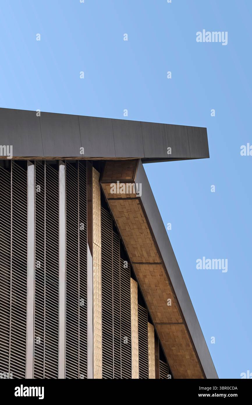 Abstrakte architektonische Details der Dachlinie und der Lamellenfassade eines modernen Gebäudes vor einem klaren blauen Himmel. Verfügt über starke geometrische Linien, Winkel, A Stockfoto