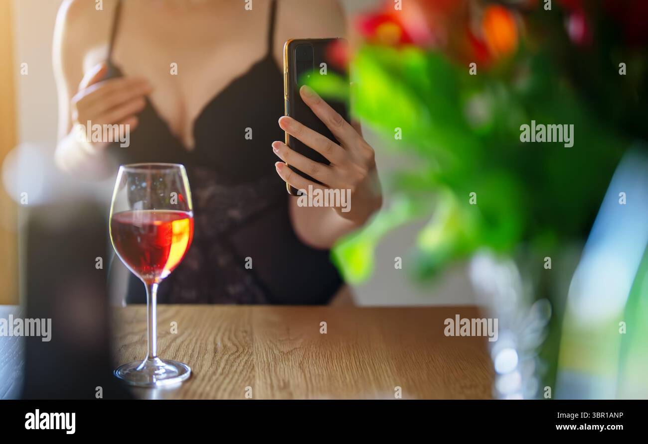 Frau in Dessous, die Selfie mit Weinglas macht. Stockfoto