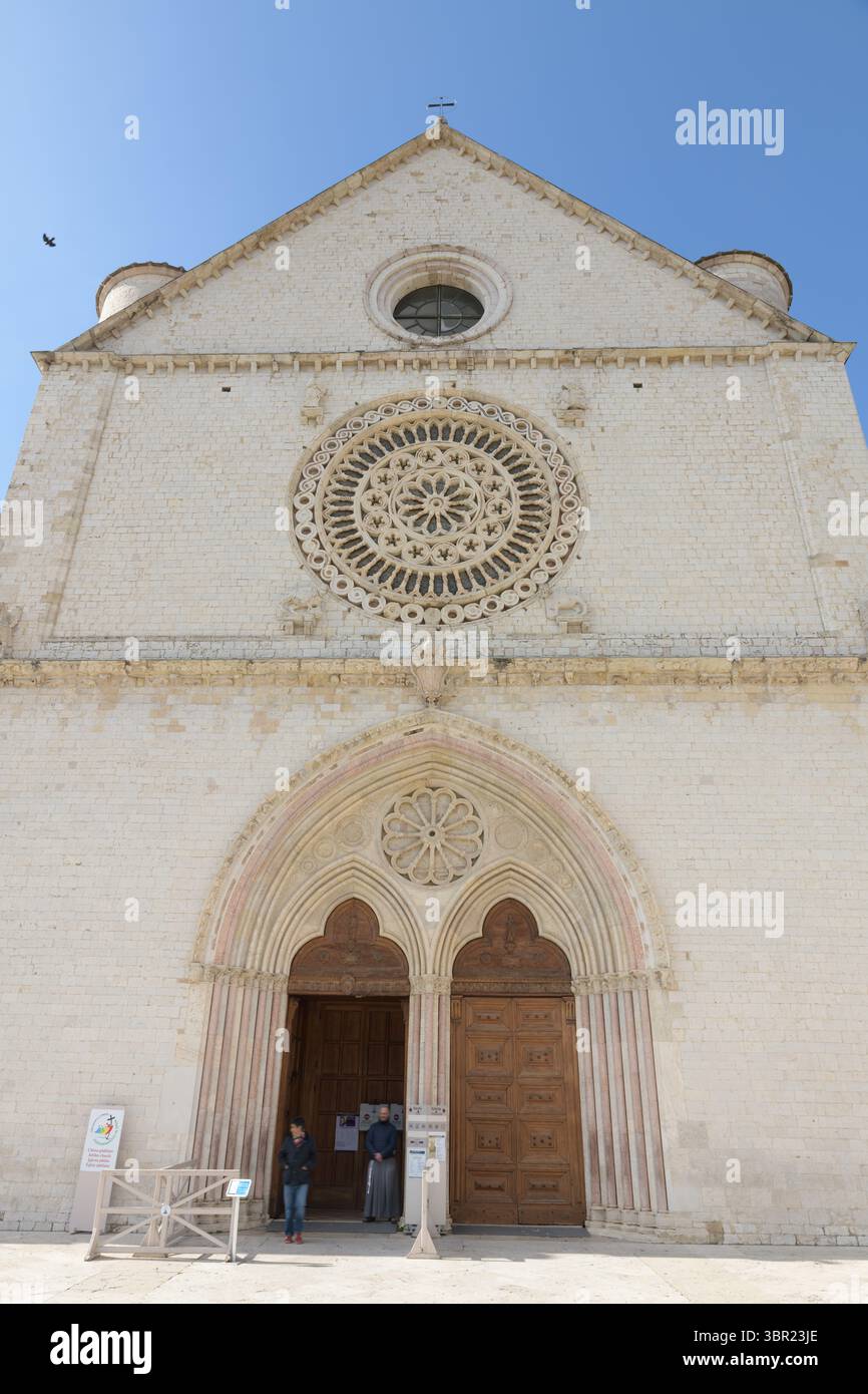 Fassade der oberen Basilika des Heiligen Franziskus in Assisi, Umbrien, Italien, mit aufwendigem Rosenfenster und spitzem gotischem Portal. Stockfoto